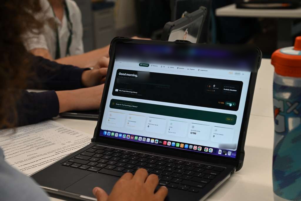 A student working through the InvestiPlay dashboard on a laptop during a pilot class